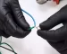 hands-with-black-gloves-connecting-wires-1